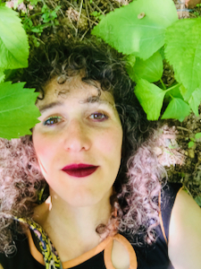 A photo of Vilde Chaya laying in a field of jewelweed and clearweed