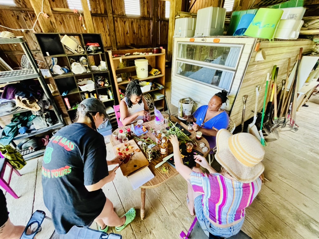 A fish-eyed photograph of 2025 Racemes sitting in the rustic Cutting Root barn, dicing luscious, colorful fruits and aromatic herbs for shrubs.